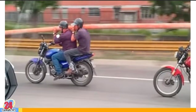 ¡Trabajo en conjunto! Mira como llevan un tubo en Caracas en moto (VÍDEO)