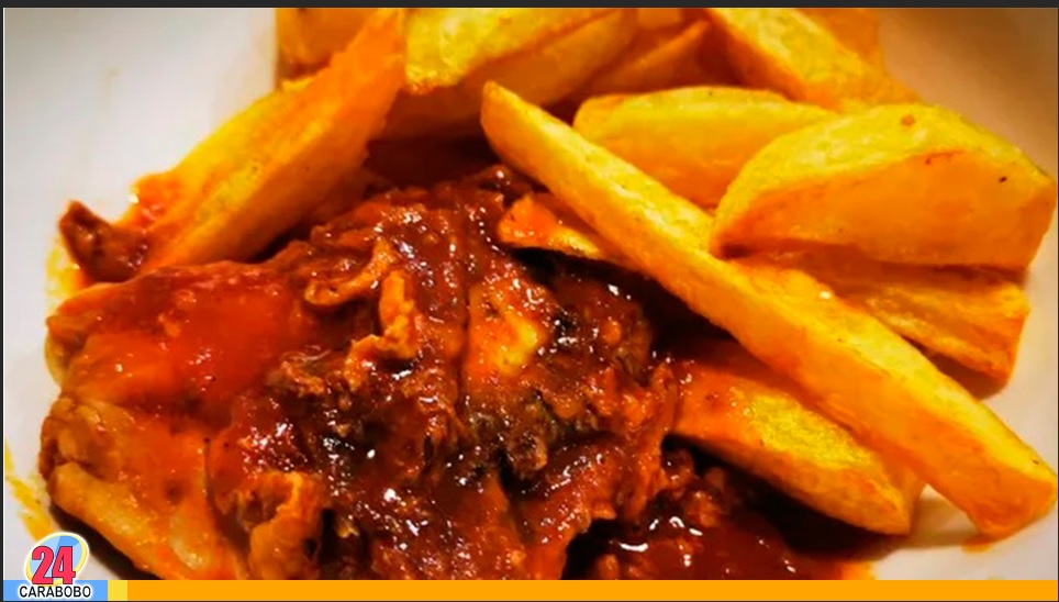 Pollo frito en salsa de tomate y papas fritas